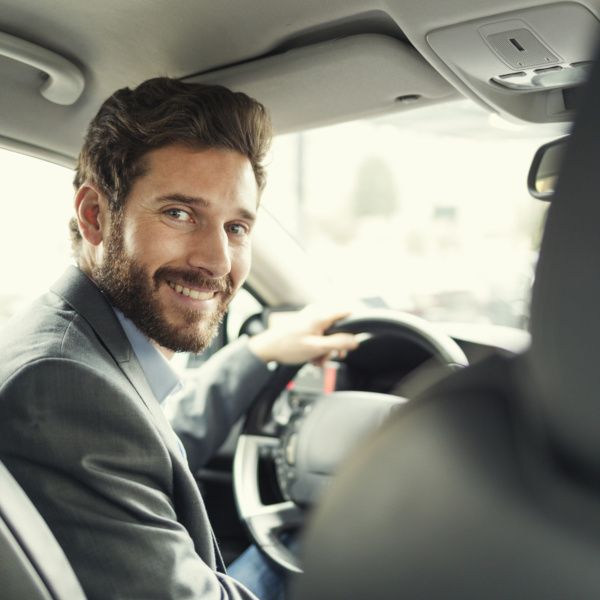 Chauffeur souriant au passager arrière